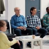 Diverse group of people sitting together in hospital waiting room